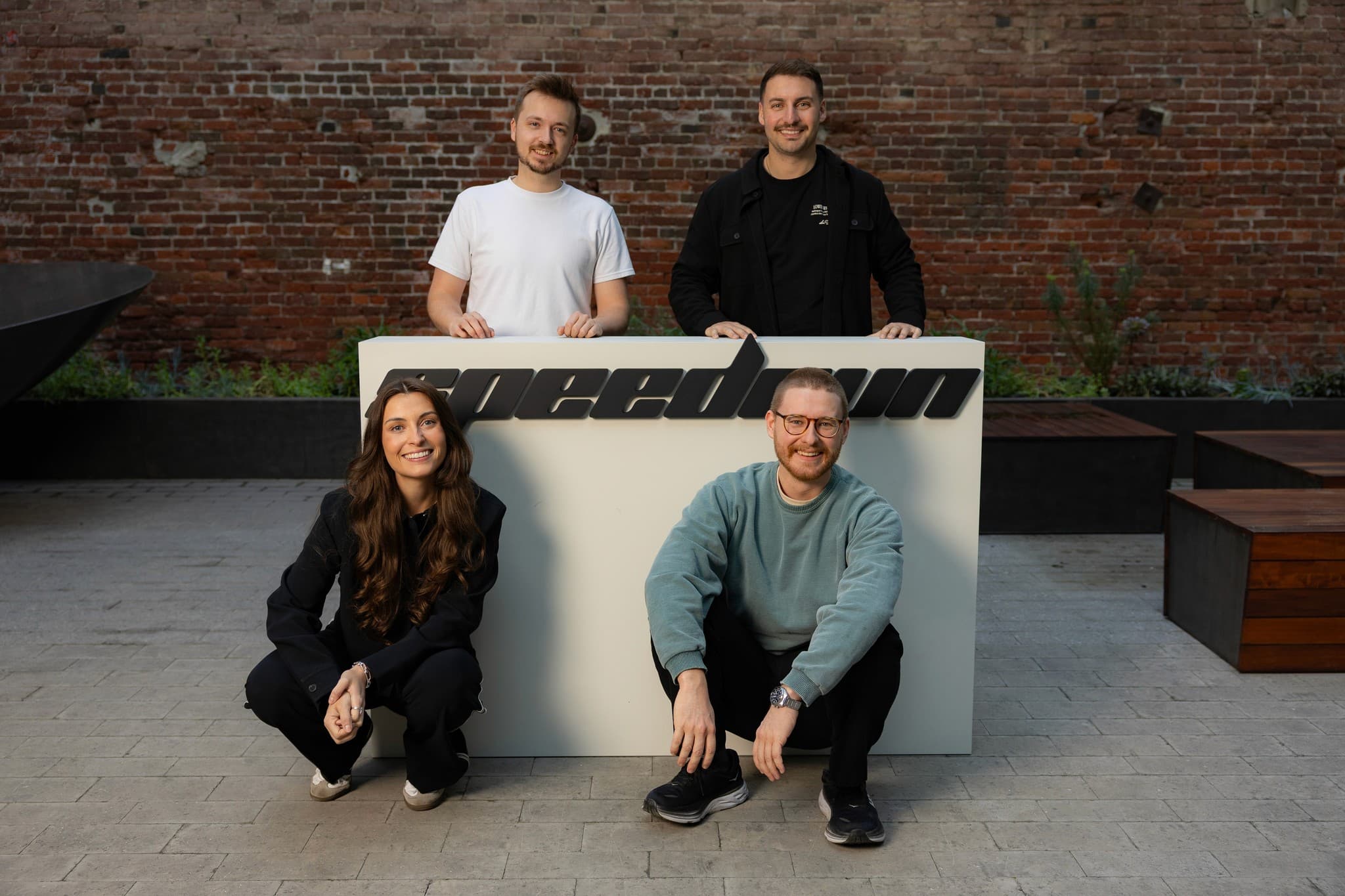The four founders of Pluvo pose with a large white Speedrun sign